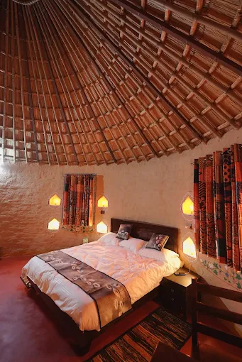 Handcrafted earthen cottage interior with thatched dome ceiling and Rajasthani lantern niches